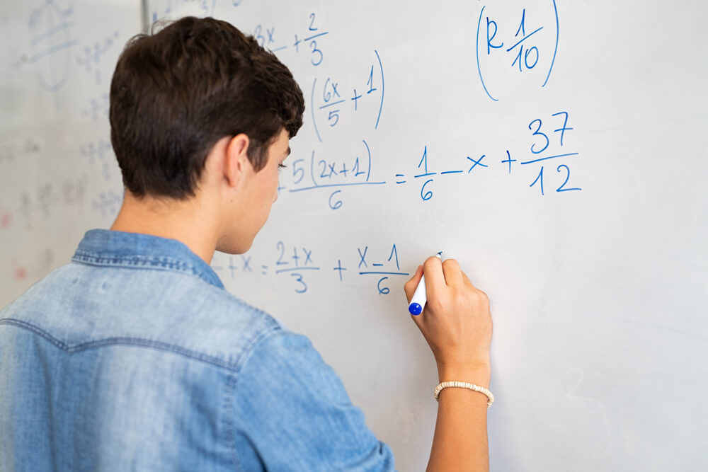 studente alla lavagna risolve problemi di matematica per prove invalsi 24