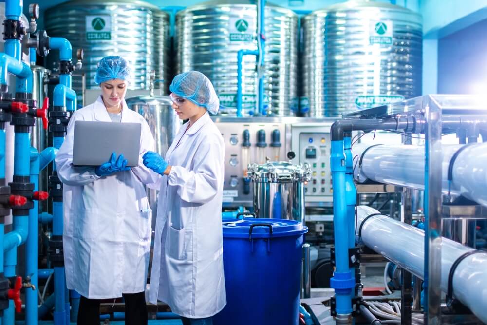 chimici indutriale con camice e cuffia