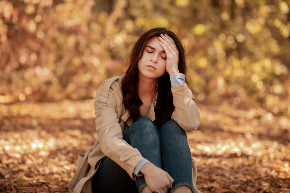 ragazza stressata in autunno porta la mano alla fronte