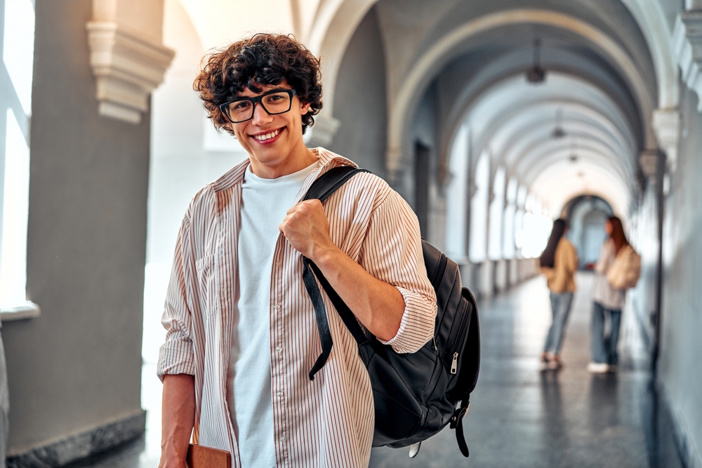 studente con zaino in spalla in porticato università