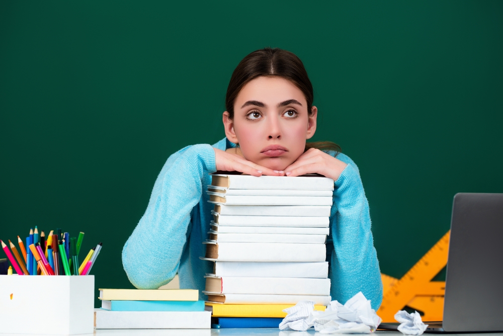 studentessa con libri e faccia triste