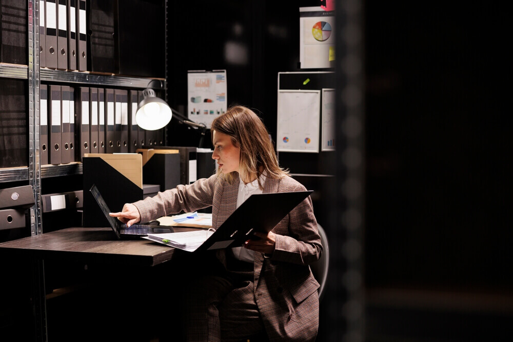 donna cerca tra documenti in un archivio per rappresentare sbocchi lavorativi di un corso di laurea in criminologia