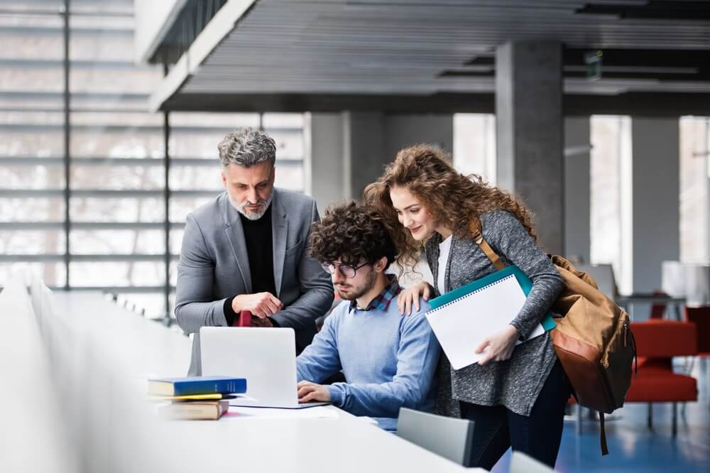 professori assistono studente nello studio per rappresentare servizio pomest dell'università ecampus