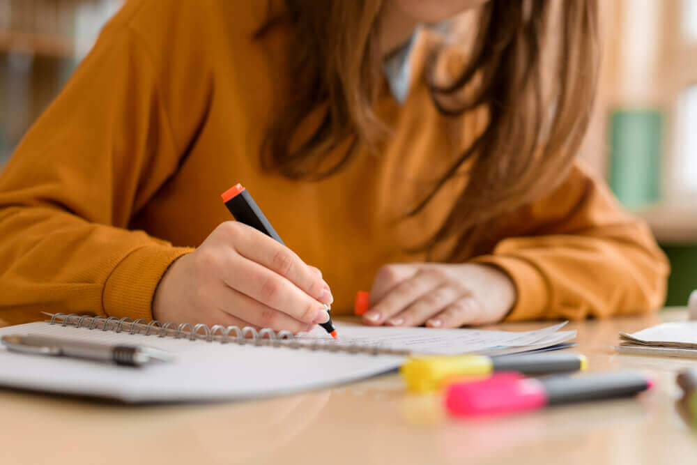 ragazza prende appunti durante lezione online