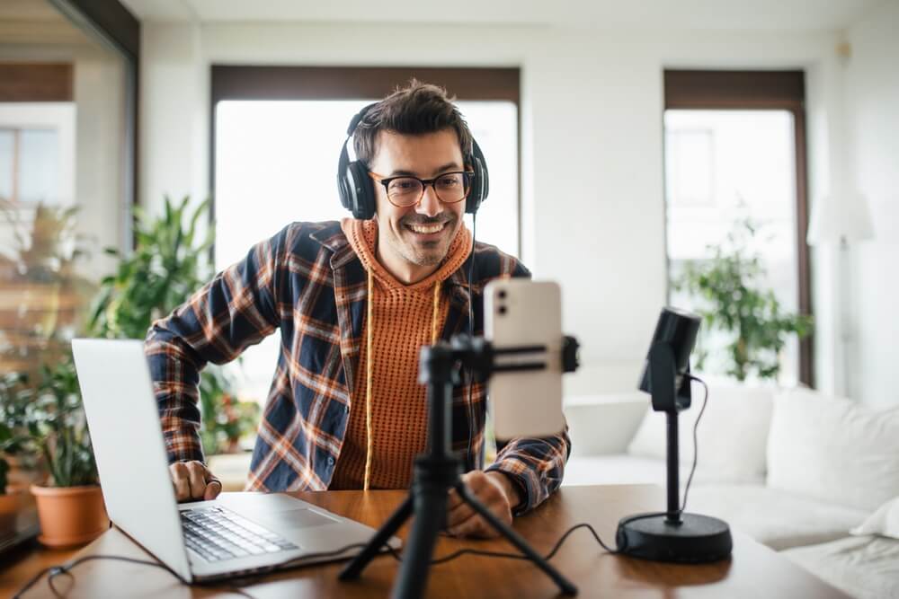 influencer che porta occhiali e camicia a quadri con microfono