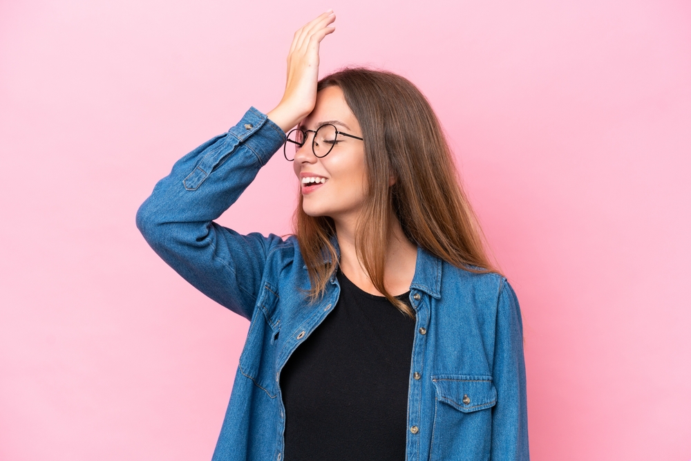ragazza con occhiali da vista porta la mano alla testa per concentrarsi