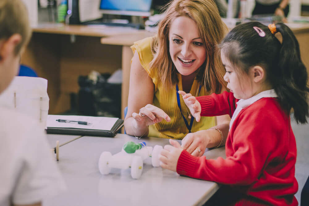 insegnante delle elementari parla con bambina per rappresentare corsi per docenti precari o con titolo estero