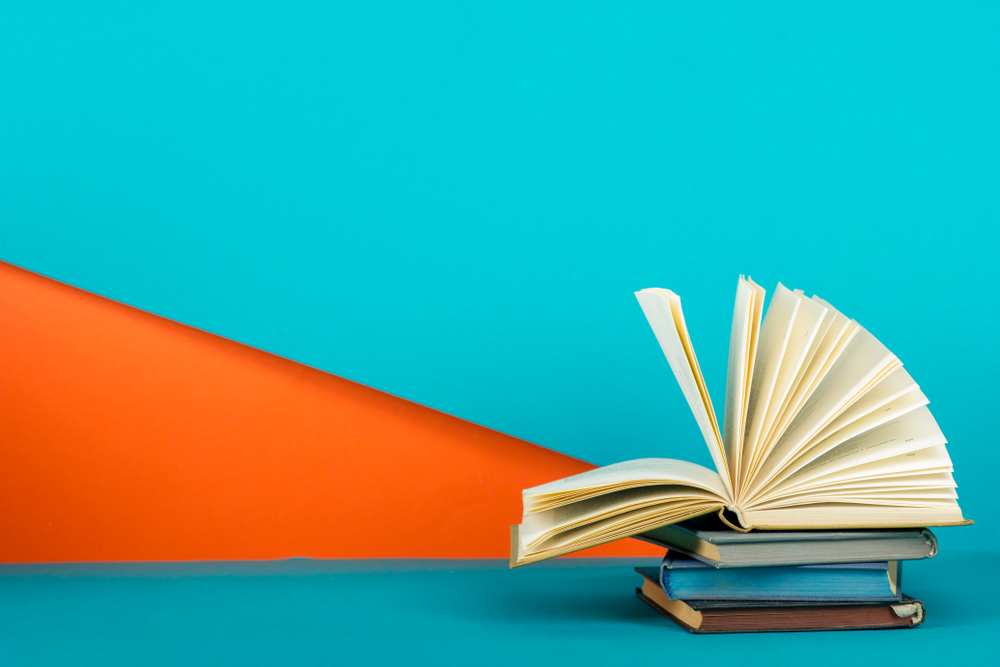 libro aperto su sfondo celeste e arancione
