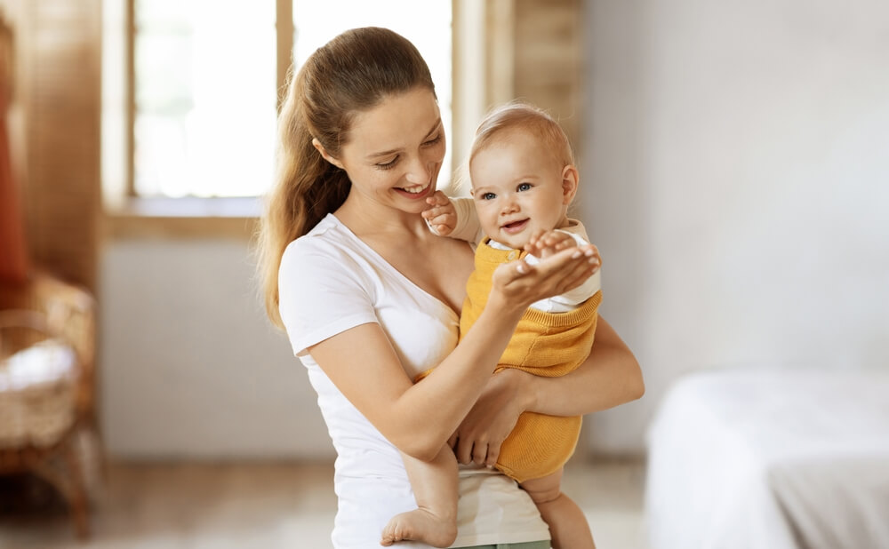 Madre tiene in braccio il figlio, entrambi sorridono