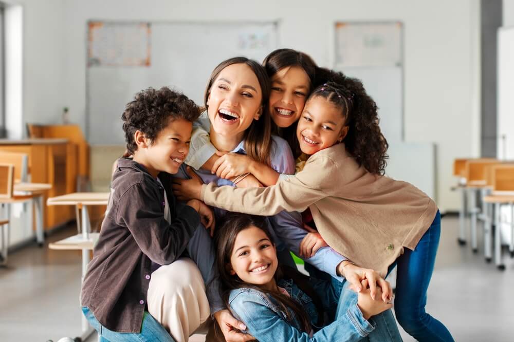 Atmosfera amichevole in classe, maestra e alunni si abbracciano