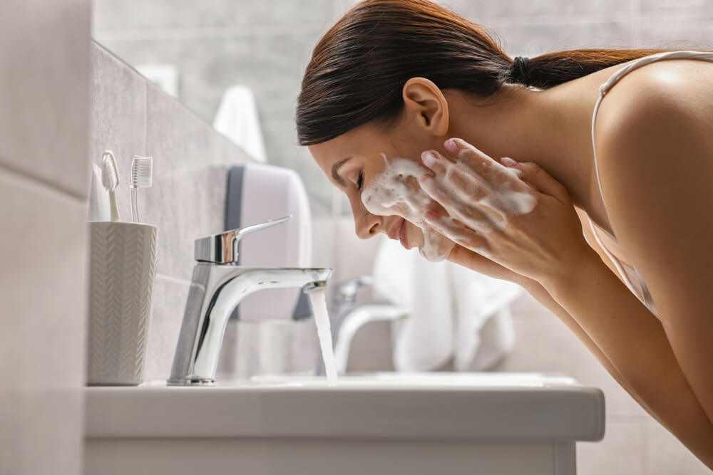 donna si lava la faccia con schiuma sul viso
