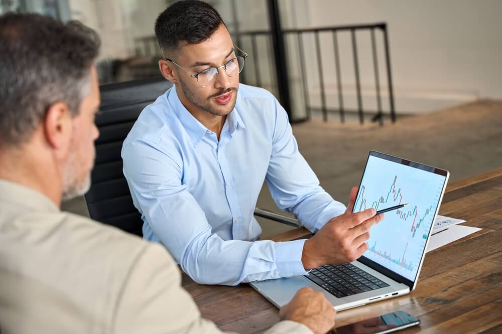 Consulente finanziario che spiega i dati del mercato azionario e fornisce consulenza agli investitori