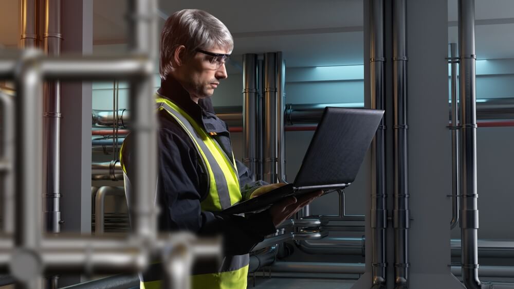 Ingegnere industriale chimico consulta il pc in una fabbrica
