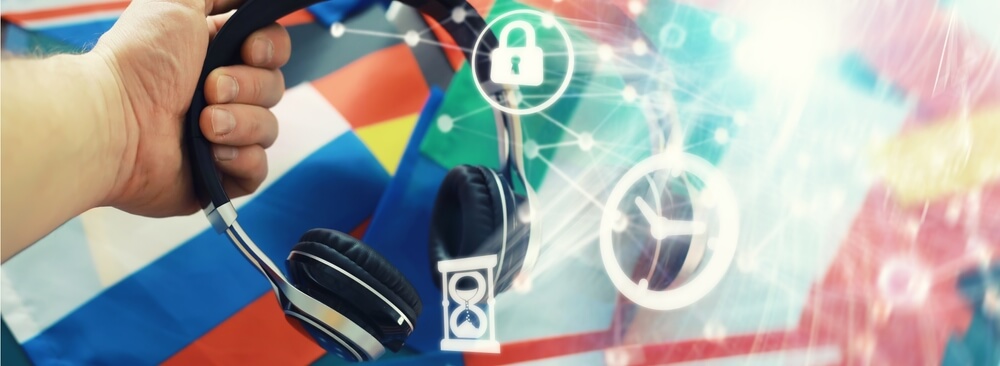 Mano che regge cuffie acustiche con sullo sfondo bandiere europee