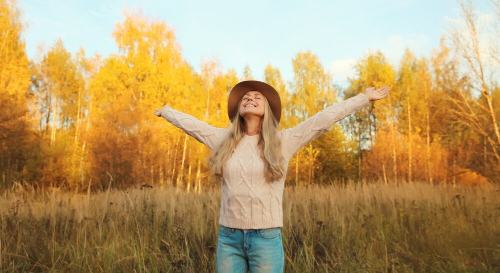 Happy,Smiling,Woman,In,Autumn,Park,Raising,Her,Hands,Up, Donna felice sorride a braccia aperte immersa in un'atmosfera autunnale