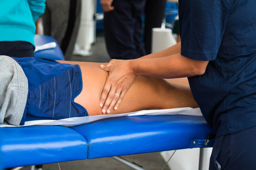 shutterstock_384244744 fisioterapista sportivo tratta quadricipite di un paziente per rappresentare master in fisioterapia sportiva