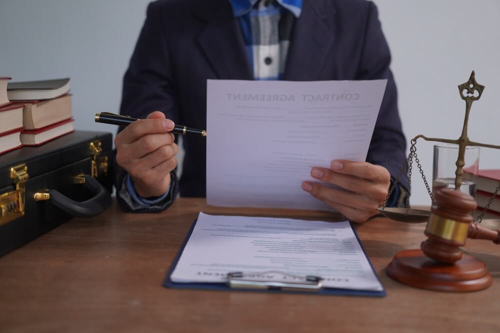 Avvocato, alla scrivania, legge dei documenti