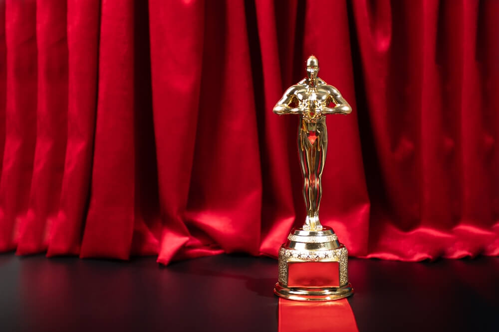 Oscar,Award,On,The,Red,Carpet,,Luxury,Movie,Prize,,Academy premio oscar sul palcoscenico con sipario rosso dietro