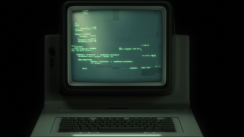 Pc retro con codice sorgente visualizzato sul monitor