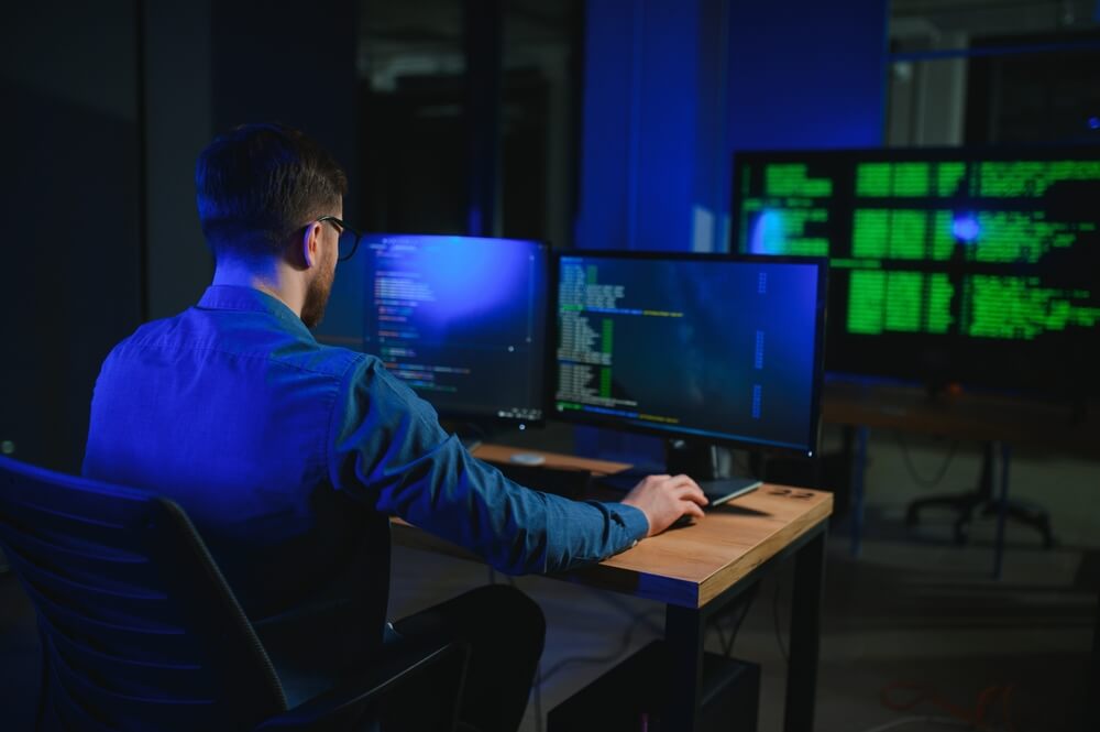 Ingegnere informatico alla scrivania elabora dati al pc