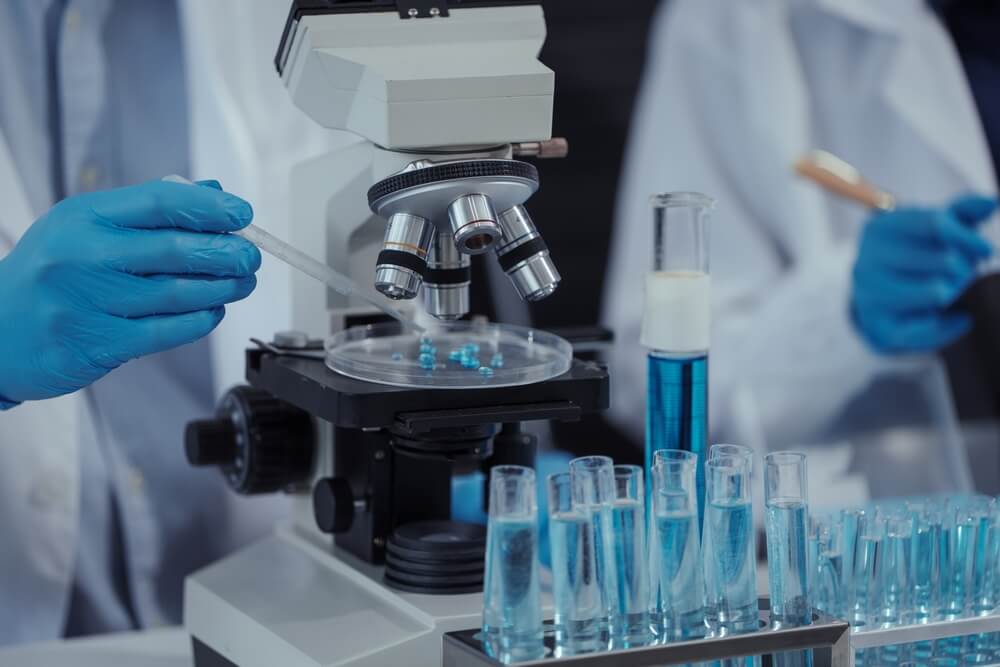 Team di scienziati lavora in moderni microscopi da laboratorio