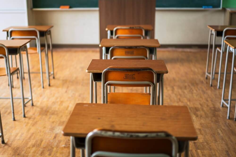 banchi vuoti in aula scolastica per rappresentare dispersione scolastica in italia