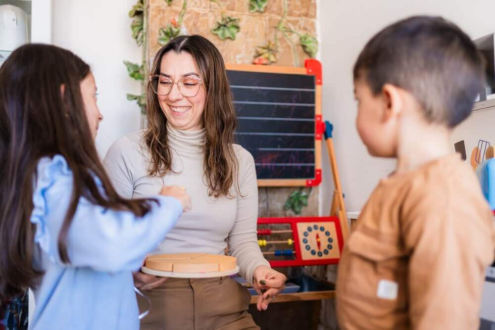pedagogista al lavoro in un'aula scolastica con due bambini per rappresentare la laurea magistrale pedagogia e scienze umane lm-85