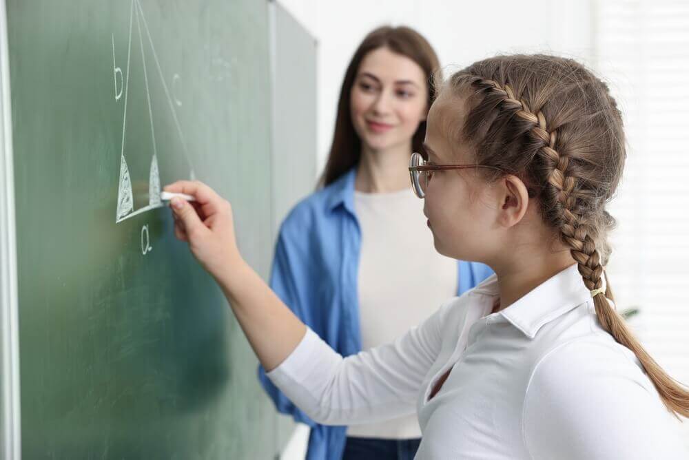 alunna alla lavagna per esercizio di geometria per rappresentare master insegnamento matematica e scienze cdc a-28