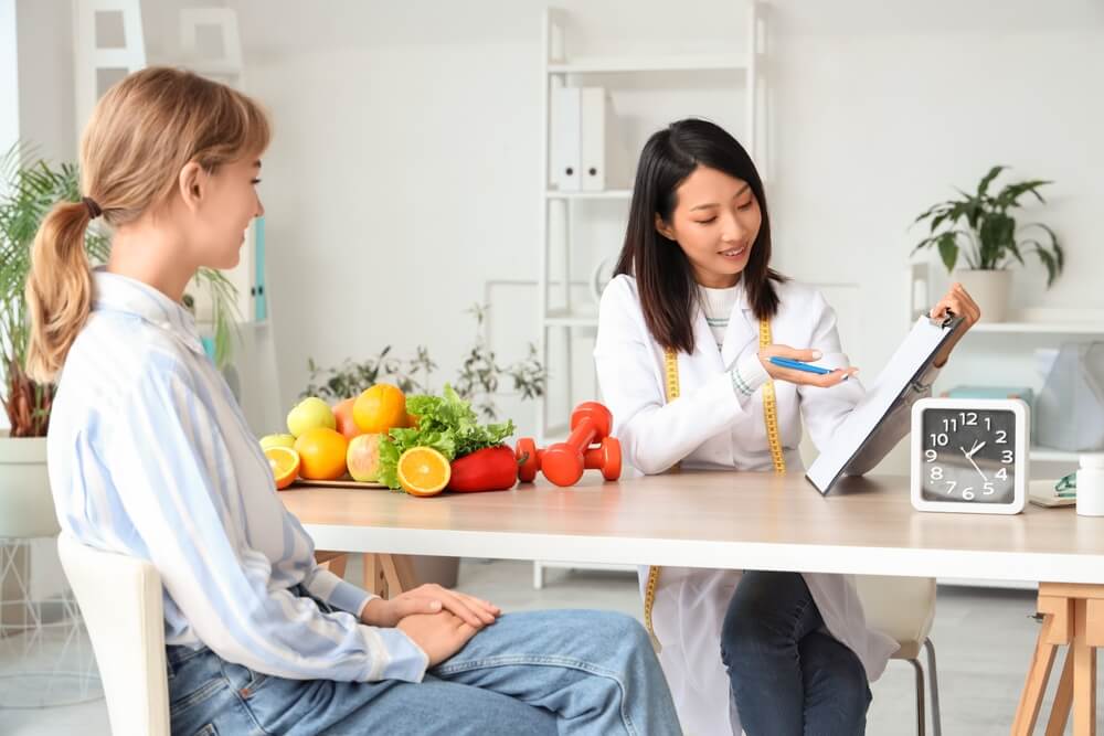 Biologo nutrizionista stila piano alimentare e lo mostra a una paziente