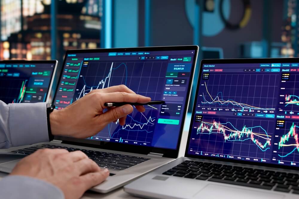 Consulente finanziario monitora le tendenze di mercato sui notebook