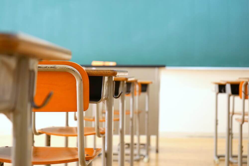 banchi di scuola in classe davanti alla lavagna per rappresentare nuove Indicazioni Nazionali Licei