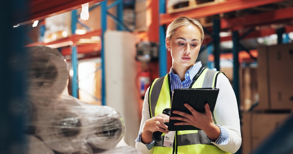 Supply chain manager donna in un magazzino con laptop in mano