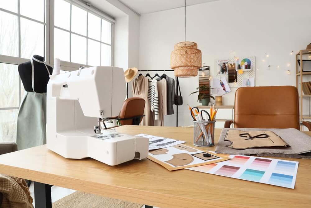 Fashion,Designer’s,Workplace,With,Sewing,Machine,In,Studio Laboratorio di Fashion designer con busto sartoriale e macchina da cucire