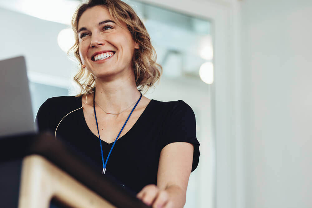 shutterstock_1853350120 donna sorridente affronta esame orale con sicurezza grazie alle tecniche di public speaking per migliorare capacità di esposizione per esami orali