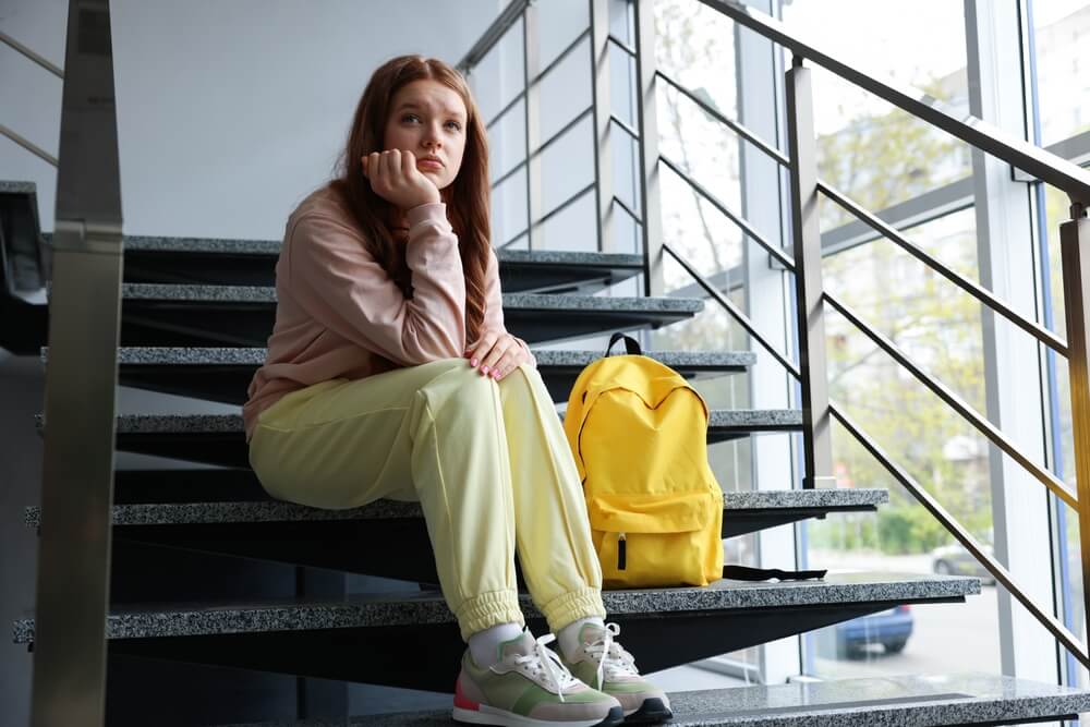 ragazza triste sulle scale della facoltà