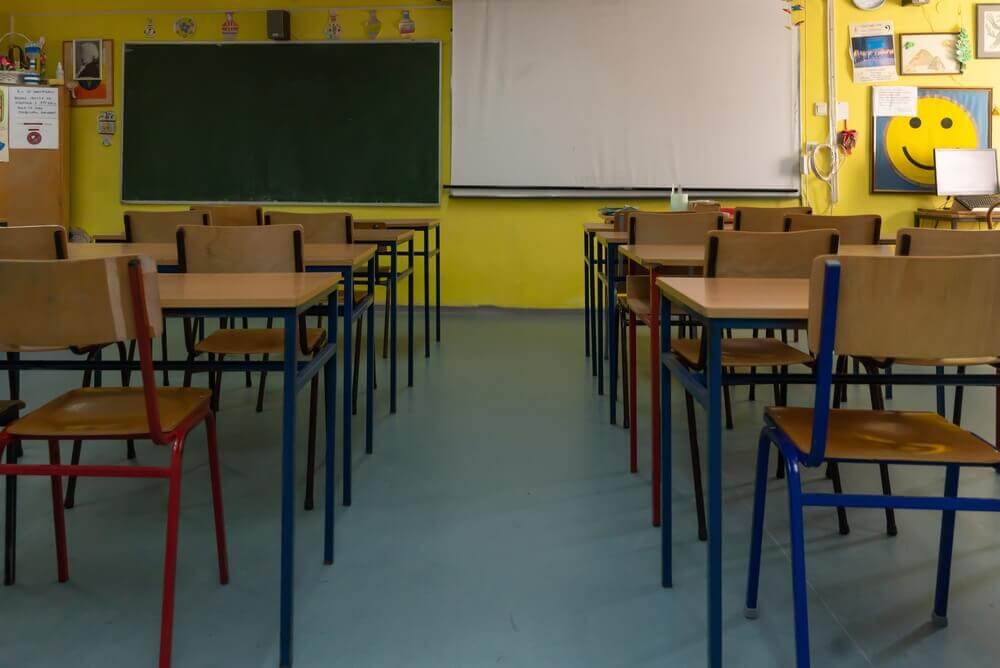 aula di una scuola vuota con banchi e lavagna per rappresentare master management della scuola il dsga
