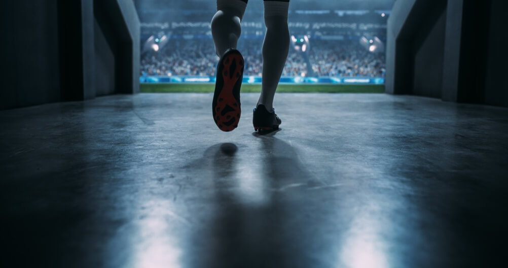 Vista di giocatore maschio che corre verso il campo di calcio