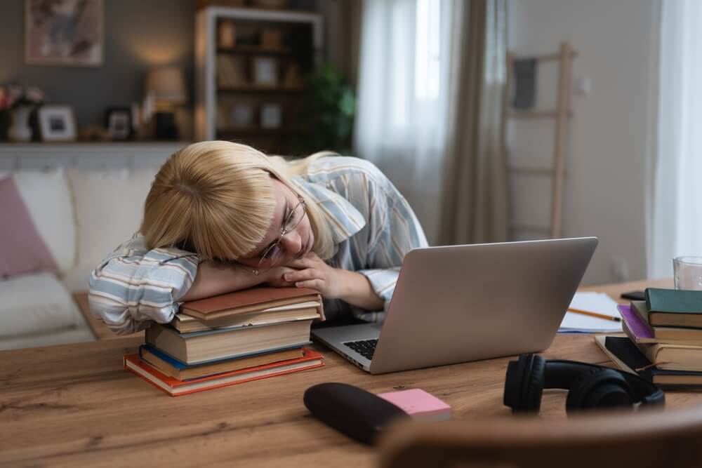 Young,Tired,University,Student,Tired,From,Study,For,Exam,Sleeping studentessa si addormenta sui libri davanti al pc