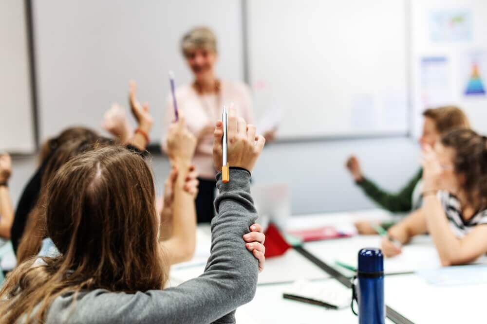 studenti alzano la mano in classe per rappresentare rapporto ocse 2026 italia